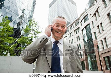 Businessman in city on cellphone View Large Photo Image Stock Photography - Businessman in city on cellphone. Fotosearch