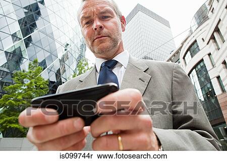 Businessman using smartphone and the go View Large Photo Image Stock Photography - Businessman using smartphone and the go. Fotosearch