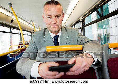 Businessman using smartphone on bus View Large Photo Image Picture - Businessman using smartphone on bus. Fotosearch