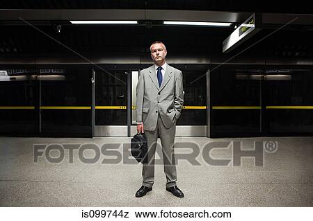 Stock Photo - Businessman waiting on subway platform. Fotosearch
