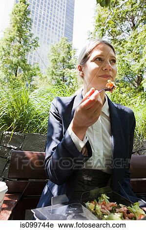 Businesswoman eating salad outdoors View Large Photo Image Stock Image - Businesswoman eating salad outdoors. Fotosearch