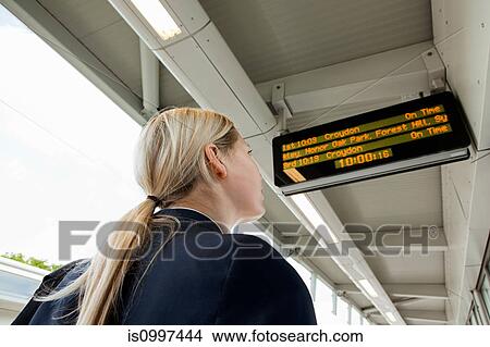 Businesswoman looking at departure board in station View Large Photo Image Picture - Businesswoman looking at departure board in station. Fotosearch