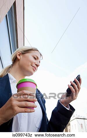 Stock Photo - Businesswoman with coffee and smart phone. Fotosearch