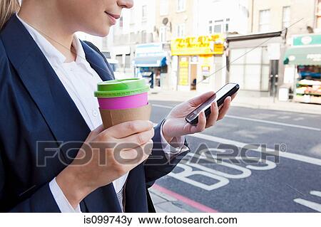 Close of businesswoman on street with coffee and smart phone View Large Photo Image Stock Photo - Close of businesswoman on street with coffee and smart phone. Fotosearch