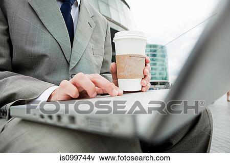 Stock Photo - Close up of businessman with laptop and coffee outdoors. Fotosearch