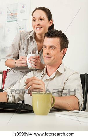 Picture - Colleagues looking at a computer screen together. Fotosearch