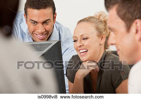 Colleagues looking at a computer screen together View Large Photo Image Stock Photo - Colleagues looking at a computer screen together. Fotosearch