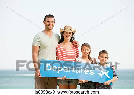 Family holding an airport departures sign on a beach View Large Photo Image Stock Photo - Family holding an airport departures sign on a beach. Fotosearch