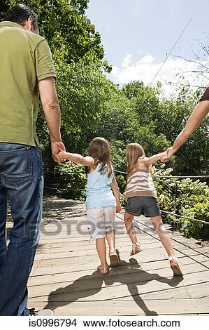Family with two girls, holding hands View Large Photo Image Picture - Family with two girls, holding hands. Fotosearch