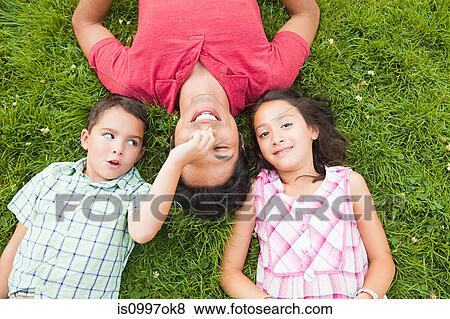 Father lying on grass with son and daughter View Large Photo Image Stock Photo - Father lying on grass with son and daughter. Fotosearch