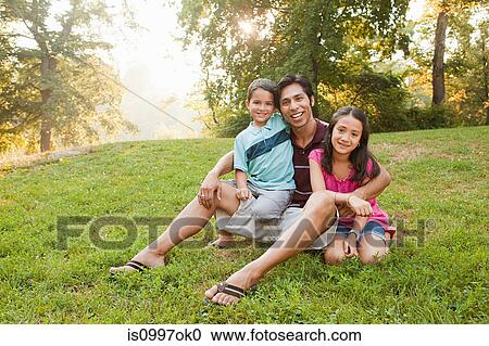 Father sitting with children in park, portrait View Large Photo Image Stock Image - Father sitting with children in park, portrait. Fotosearch
