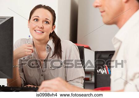 Female employee gazing longingly at her male colleague View Large Photo Image Picture - Female employee gazing longingly at her male colleague. Fotosearch