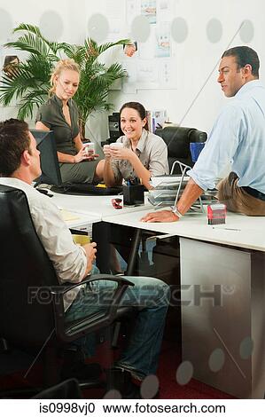 Four office workers having an informal meeting View Large Photo Image Stock Image - Four office workers having an informal meeting. Fotosearch
