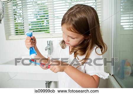 Girl applying toothpaste to brush in bathroom View Large Photo Image Stock Image - Girl applying toothpaste to brush in bathroom. Fotosearch