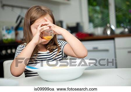 Girl drinking orange juice at table View Large Photo Image Stock Image - Girl drinking orange juice at table. Fotosearch