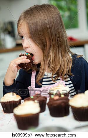 Girl eating chocolate cup cake View Large Photo Image Stock Photo - Girl eating chocolate cup cake. Fotosearch