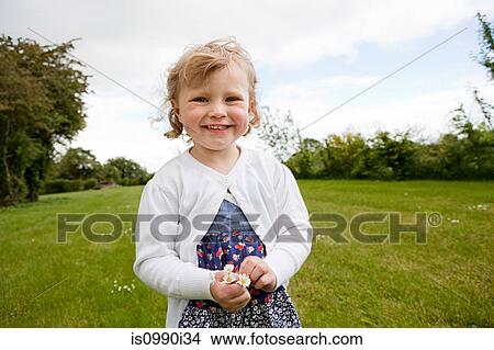 Girl holding daisies, looking at camera View Large Photo Image Picture - Girl holding daisies, looking at camera. Fotosearch