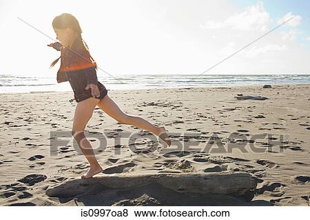 Girl running along beach View Large Photo Image Stock Photo - Girl running along beach. Fotosearch