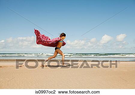 Girl running with blanket at beach View Large Photo Image Stock Image - Girl running with blanket at beach. Fotosearch