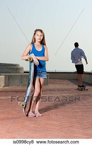 Stock Photo - Girl standing with skateboard. Fotosearch
