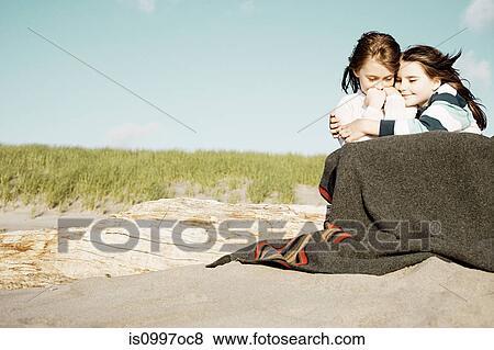 Girls hugging in blanket at beach View Large Photo Image Stock Photo - Girls hugging in blanket at beach. Fotosearch
