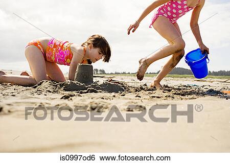 Girls making sandcastles at beach View Large Photo Image Stock Photograph - Girls making sandcastles at beach. Fotosearch
