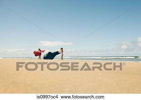 Girls running with blankets at beach View Large Photo Image Picture - Girls running with blankets at beach. Fotosearch