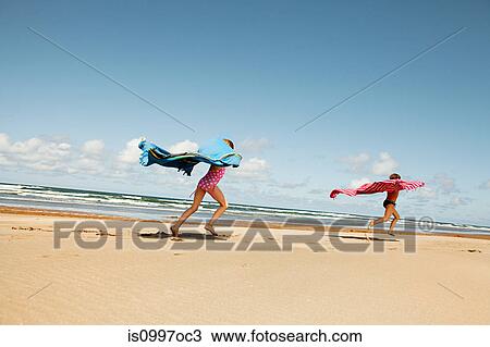 Girls running with blankets at beach View Large Photo Image Stock Image - Girls running with blankets at beach. Fotosearch