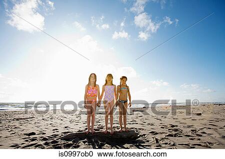 Girls standing on beach holding hands View Large Photo Image Stock Image - Girls standing on beach holding hands. Fotosearch