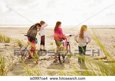 Girls standing with bikes at beach View Large Photo Image Picture - Girls standing with bikes at beach. Fotosearch