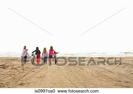 Girls walking over sand at beach View Large Photo Image Stock Image - Girls walking over sand at beach. Fotosearch