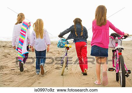 Girls walking over sand at beach View Large Photo Image Stock Photo - Girls walking over sand at beach. Fotosearch