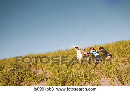 Girls walking through long grass at beach View Large Photo Image Stock Image - Girls walking through long grass at beach. Fotosearch