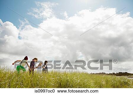 Girls walking through long grass View Large Photo Image Stock Image - Girls walking through long grass. Fotosearch