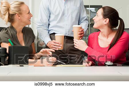 Male colleague bringing female colleagues coffee View Large Photo Image Stock Photography - Male colleague bringing female colleagues coffee. Fotosearch