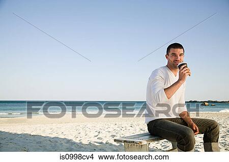 Man drinking coffee on a beach View Large Photo Image Picture - Man drinking coffee on a beach. Fotosearch