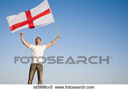 Man holding St George's Cross flag in the air View Large Photo Image Stock Image - Man holding St George's Cross flag in the air. Fotosearch