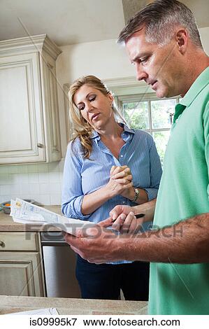Mature couple looking at household bills View Large Photo Image Stock Photo - Mature couple looking at household bills. Fotosearch