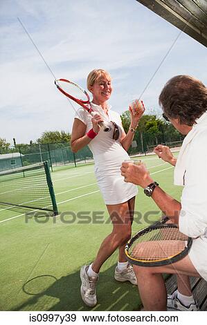 Mature couple resting during tennis match View Large Photo Image Stock Photo - Mature couple resting during tennis match. Fotosearch