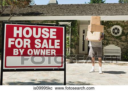 Stock Image - Mature man carrying boxes to move into newly bought property. Fotosearch