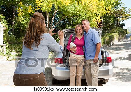 Picture - Mature woman photographing family. Fotosearch