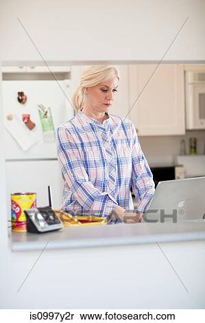 Stock Photography - Mature woman working from home. Fotosearch