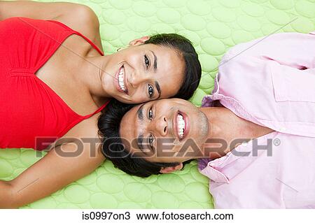 Mid adult couple lying on blanket outdoors, portrait View Large Photo Image Stock Image - Mid adult couple lying on blanket outdoors, portrait. Fotosearch