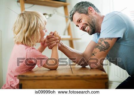 Mid adult man arm wrestling with son View Large Photo Image Stock Image - Mid adult man arm wrestling with son. Fotosearch