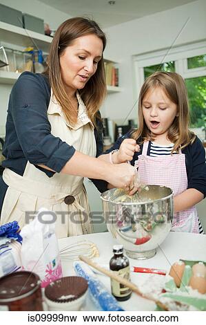 Mid adult woman baking with daughter in kitchen View Large Photo Image Stock Photo - Mid adult woman baking with daughter in kitchen. Fotosearch
