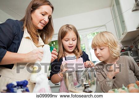 Mid adult woman baking with son and daughter in kitchen View Large Photo Image Stock Photo - Mid adult woman baking with son and daughter in kitchen. Fotosearch