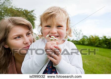 Mother and daughter holding daisies, portrait View Large Photo Image Stock Image - Mother and daughter holding daisies, portrait. Fotosearch