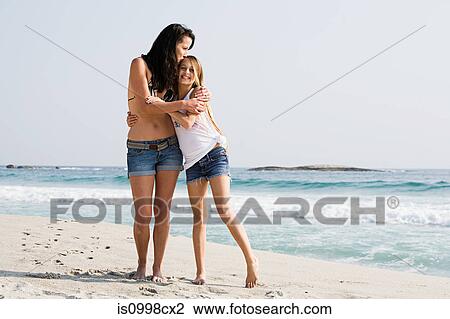 Mother and daughter hugging on a beach View Large Photo Image Stock Image - Mother and daughter hugging on a beach. Fotosearch