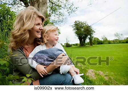 Mother and daughter sitting in field, looking away View Large Photo Image Stock Photo - Mother and daughter sitting in field, looking away. Fotosearch