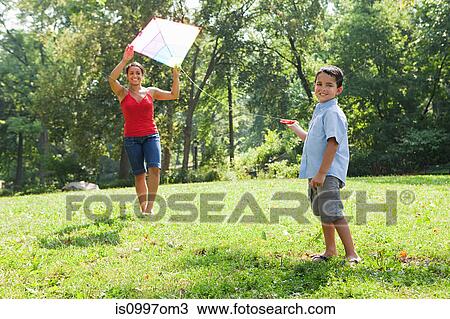 Mother holding kite with son in park View Large Photo Image Stock Image - Mother holding kite with son in park. Fotosearch